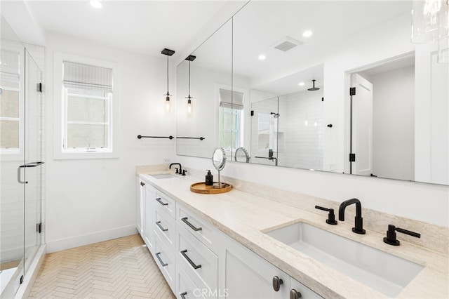 bathroom with visible vents, a sink, a shower stall, and double vanity