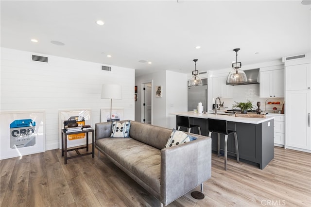 living area featuring visible vents, recessed lighting, and light wood-style floors