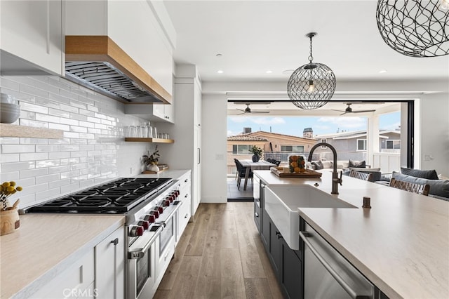 kitchen with ceiling fan, stainless steel appliances, light countertops, and a sink