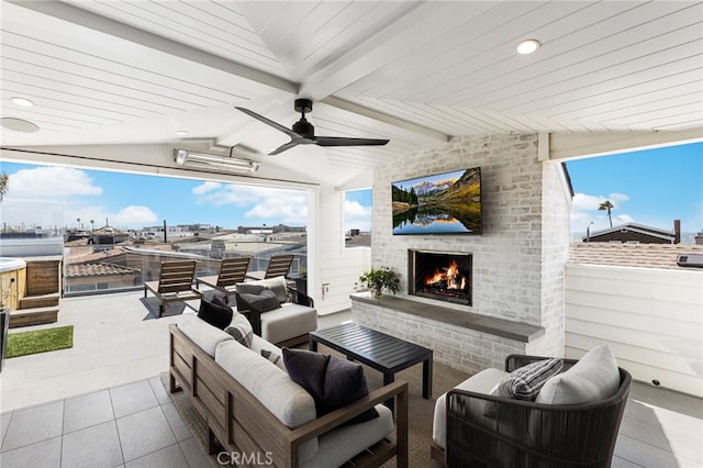 view of patio with an outdoor living space with a fireplace and a ceiling fan