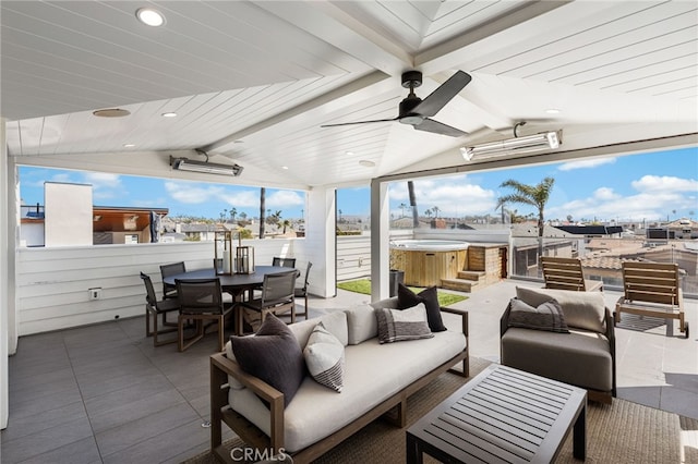 view of patio / terrace featuring a ceiling fan, outdoor lounge area, fence, outdoor dining space, and a hot tub