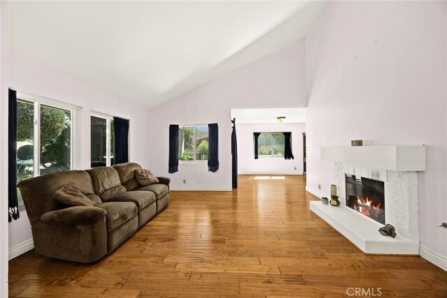 13771 De Garmo Ave, Rancho Cascades, CA 91342 - living room with a glass covered fireplace, healthy amount of natural light, light wood-style flooring, and high vaulted ceiling