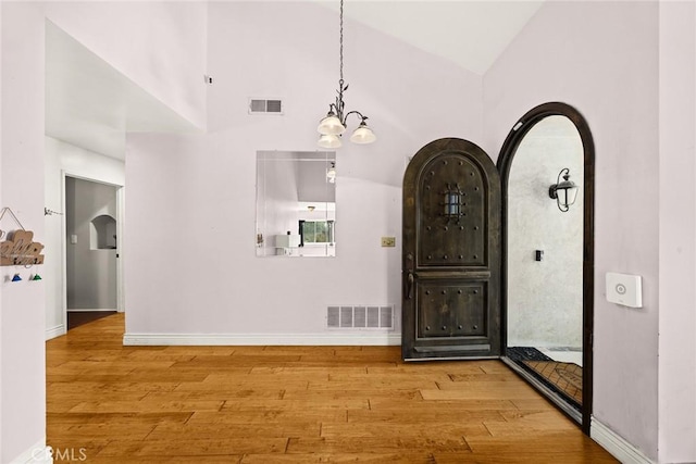 13771 De Garmo Ave, Rancho Cascades, CA 91342 - entrance foyer with arched walkways, wood finished floors, vaulted ceiling, baseboards, and a chandelier