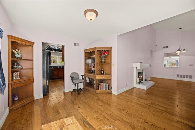 13771 De Garmo Ave, Rancho Cascades, CA 91342 - living room featuring hardwood / wood-style floors, a lit fireplace, baseboards, and vaulted ceiling