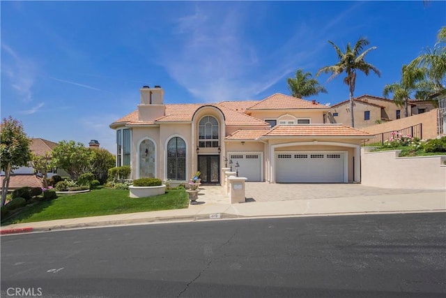 8113 Newcastle Dr, Whittier, CA 90605 - mediterranean / spanish-style house with a chimney, stucco siding, a garage, a tile roof, and driveway