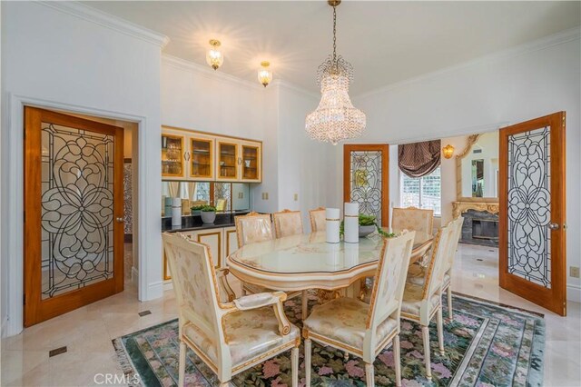8113 Newcastle Dr, Whittier, CA 90605 - dining space with light tile patterned floors, a notable chandelier, crown molding, and a glass covered fireplace
