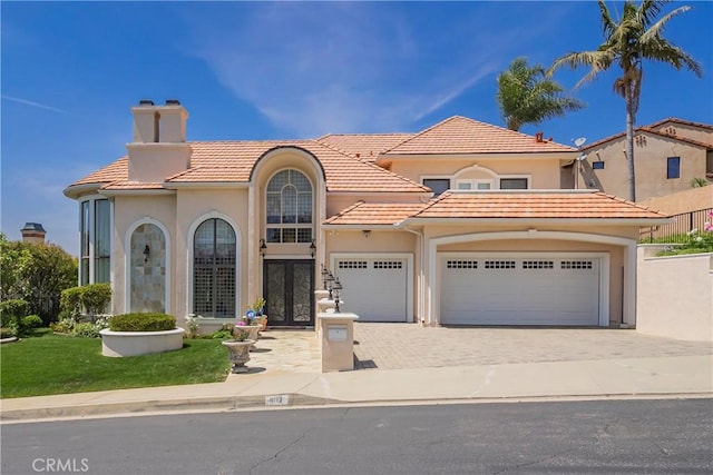 8113 Newcastle Dr, Whittier, CA 90605 - mediterranean / spanish-style house with driveway, a chimney, a tiled roof, french doors, and a garage