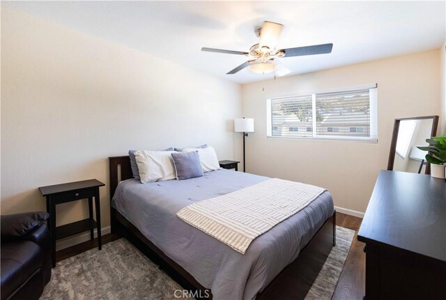 bedroom featuring a ceiling fan, baseboards, and wood finished floors