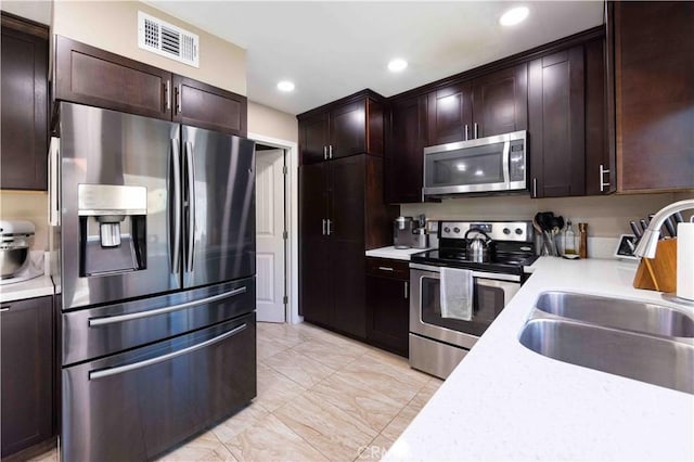 kitchen with light countertops, a sink, stainless steel appliances, and visible vents