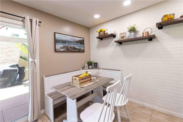 dining room featuring recessed lighting and brick wall