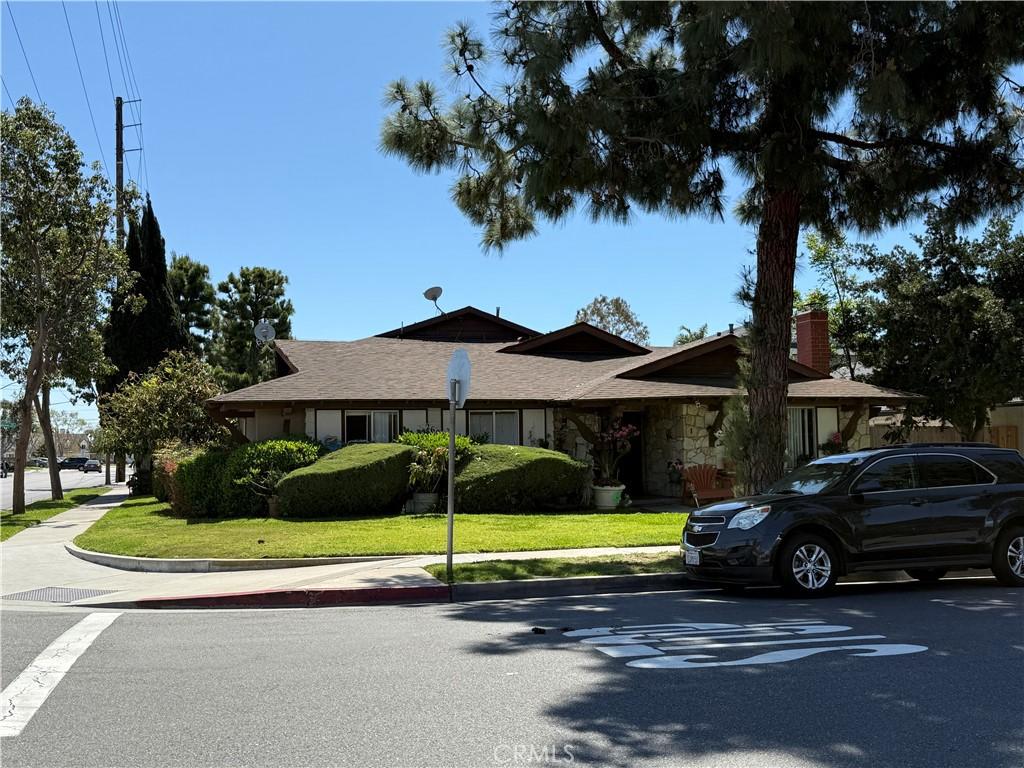 2602 W Aurora St Unit 4, Santa Ana, CA 92704 - view of front facade with stone siding, a front yard, and a chimney