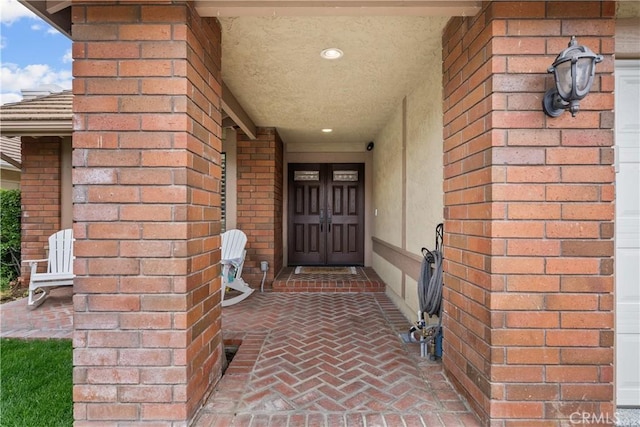 doorway to property featuring stucco siding and brick siding