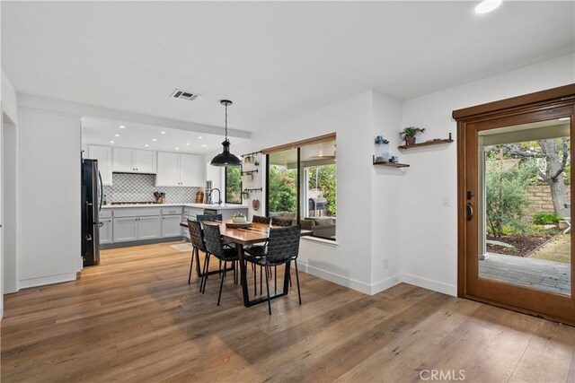 dining area featuring visible vents, recessed lighting, plenty of natural light, and light wood-style floors