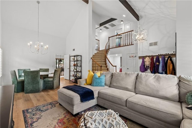 living room with high vaulted ceiling, visible vents, an inviting chandelier, and wood finished floors