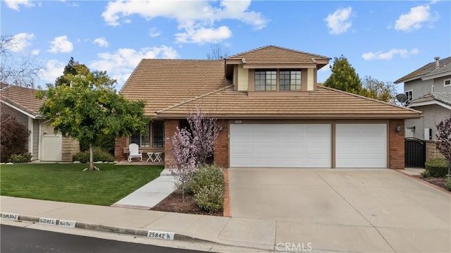 view of front of property featuring a gate, fence, a front lawn, a tile roof, and driveway