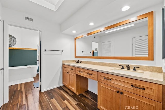 bathroom featuring a sink, visible vents, and wood finished floors