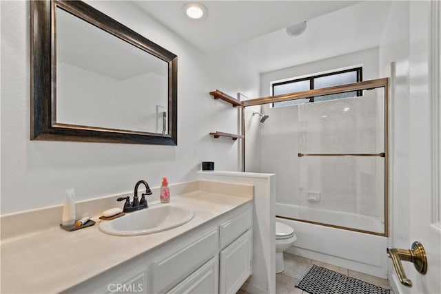 full bath with toilet, tile patterned floors, vanity, and bath / shower combo with glass door