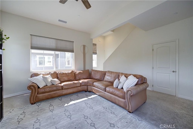carpeted living area featuring visible vents and a ceiling fan