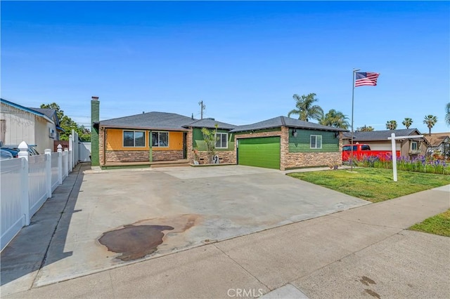 7451 Western Ave, Buena Park, CA 90620 - view of front of house featuring fence, a front lawn, concrete driveway, stone siding, and a garage