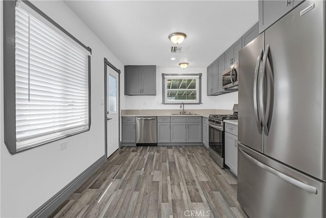 7451 Western Ave, Buena Park, CA 90620 - kitchen featuring wood finished floors, appliances with stainless steel finishes, a sink, gray cabinetry, and visible vents