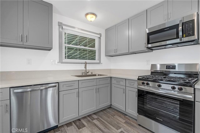 7451 Western Ave, Buena Park, CA 90620 - kitchen with a sink, appliances with stainless steel finishes, light wood-style floors, light countertops, and gray cabinets