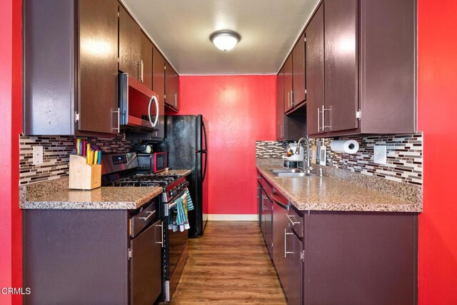 2538 Bolker Dr, Port Hueneme, CA 93041 - kitchen featuring stainless steel microwave, black gas range oven, decorative backsplash, wood finished floors, and light countertops