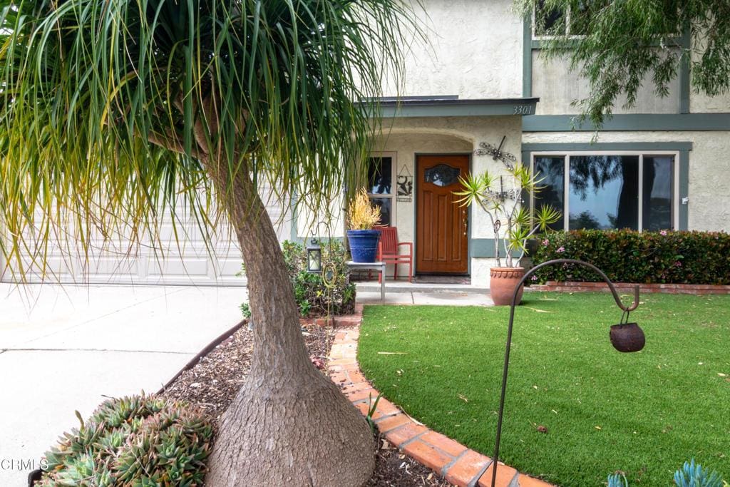 3301 Regatta Pl, Oxnard, CA 93035 - property entrance with covered porch, stucco siding, and a lawn