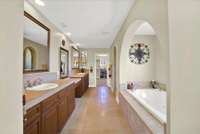 bathroom featuring a garden tub, vanity, tile patterned flooring, and recessed lighting