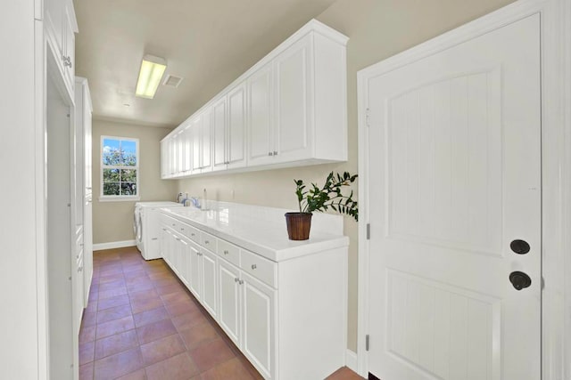 laundry room featuring washing machine and dryer, dark tile patterned floors, visible vents, and baseboards
