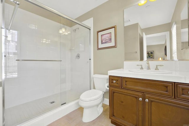 bathroom featuring a shower stall, toilet, vanity, and tile patterned flooring