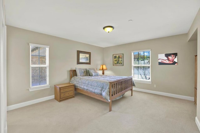 bedroom with baseboards and light colored carpet