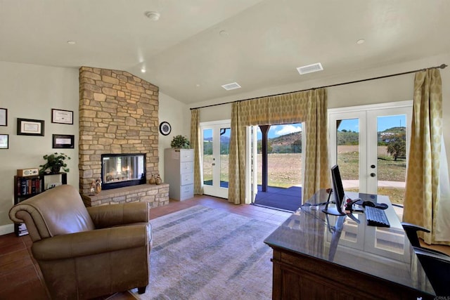 living room featuring a fireplace, vaulted ceiling, visible vents, and french doors