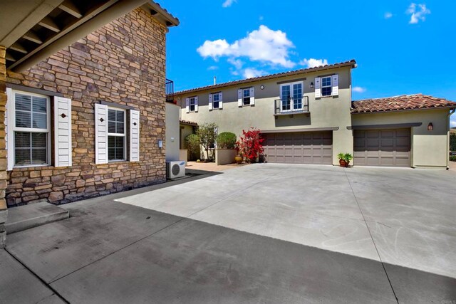 view of front of house featuring stone siding, an attached garage, stucco siding, and concrete driveway