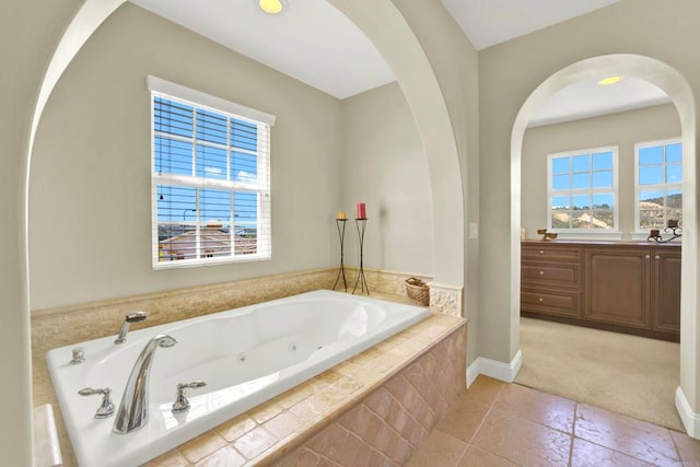 bathroom with baseboards, vanity, tile patterned floors, and a jetted tub