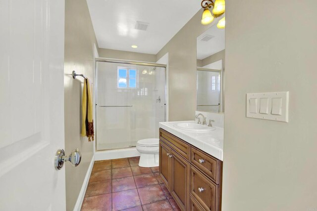 bathroom with toilet, vanity, tile patterned floors, and a stall shower