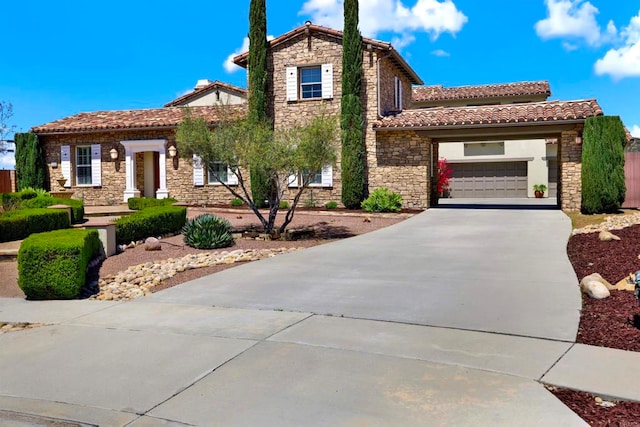 mediterranean / spanish home with stone siding, a tile roof, driveway, and a garage