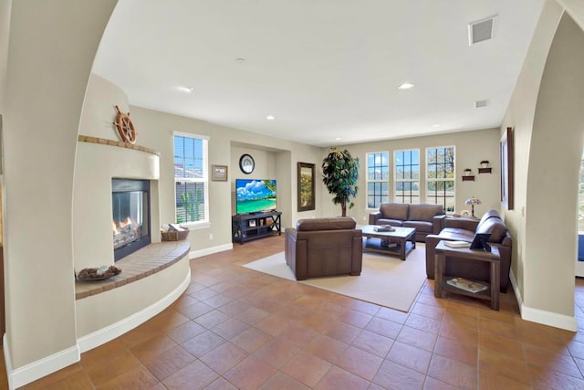 tiled living area with a wealth of natural light, visible vents, a fireplace, and recessed lighting