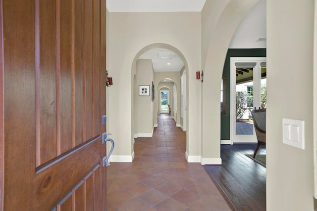entryway featuring plenty of natural light, dark tile patterned flooring, and baseboards