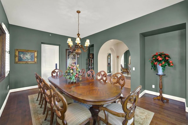 dining area with arched walkways, an inviting chandelier, a wealth of natural light, and baseboards