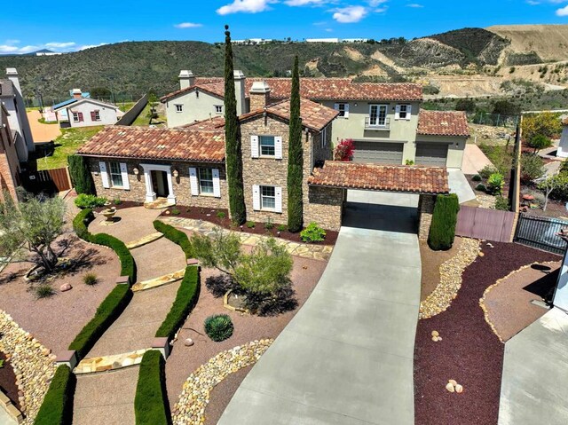 11443 Stockwood Cv, San Diego, CA 92131 - mediterranean / spanish-style home featuring a tile roof, concrete driveway, a mountain view, stone siding, and stucco siding