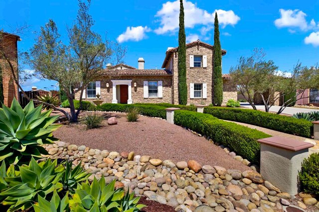 11443 Stockwood Cv, San Diego, CA 92131 - view of front of house with stone siding, a chimney, and a tiled roof