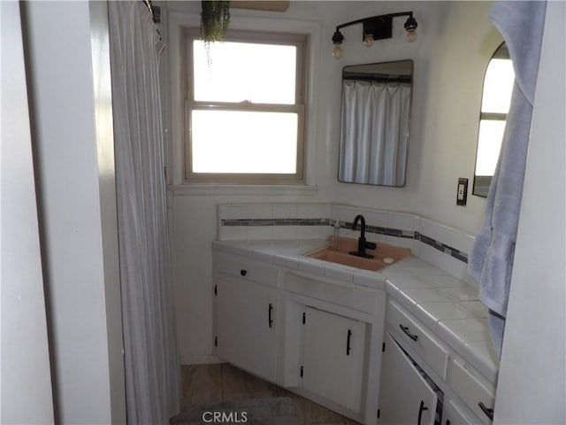 bathroom with vanity, tile patterned flooring, and tasteful backsplash