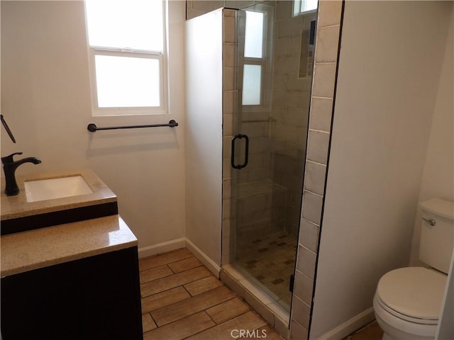 full bath featuring a stall shower, wood finished floors, vanity, baseboards, and toilet
