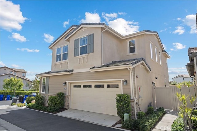 1730 Artemisia Ct, Carlsbad, CA 92011 - view of front facade with fence, stone siding, a garage, stucco siding, and driveway