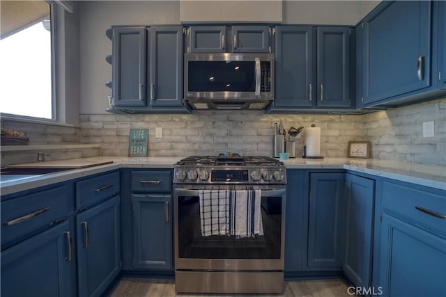 2318 Cranesbill Pl, Avila Beach, CA 93424 - kitchen with stainless steel appliances, blue cabinetry, light countertops, and tasteful backsplash