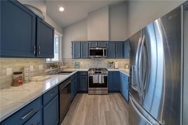 2318 Cranesbill Pl, Avila Beach, CA 93424 - kitchen with appliances with stainless steel finishes, blue cabinets, light wood-type flooring, light stone countertops, and backsplash