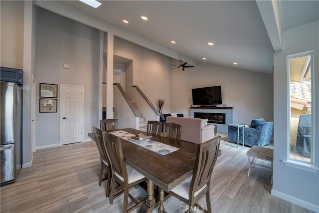 2318 Cranesbill Pl, Avila Beach, CA 93424 - dining space featuring a ceiling fan, light wood-style floors, stairs, a glass covered fireplace, and high vaulted ceiling