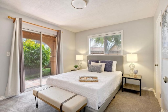 bedroom with access to exterior, carpet flooring, baseboards, and a textured ceiling