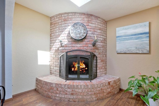 details with baseboards, wood finished floors, and a fireplace