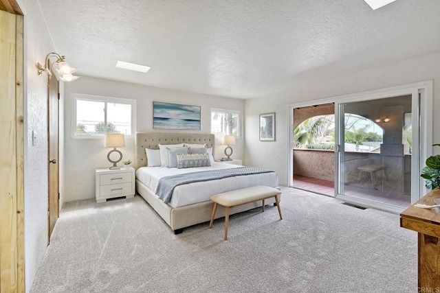 carpeted bedroom featuring visible vents, access to exterior, a textured wall, and a textured ceiling